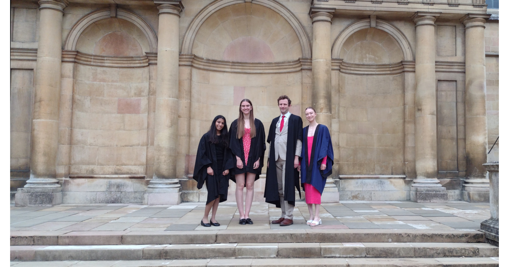 Vianca Shah, Emma Beniston, Jordan Skittrall and Ilona Basset in formal clothes and gowns in Trinity College Cambridge