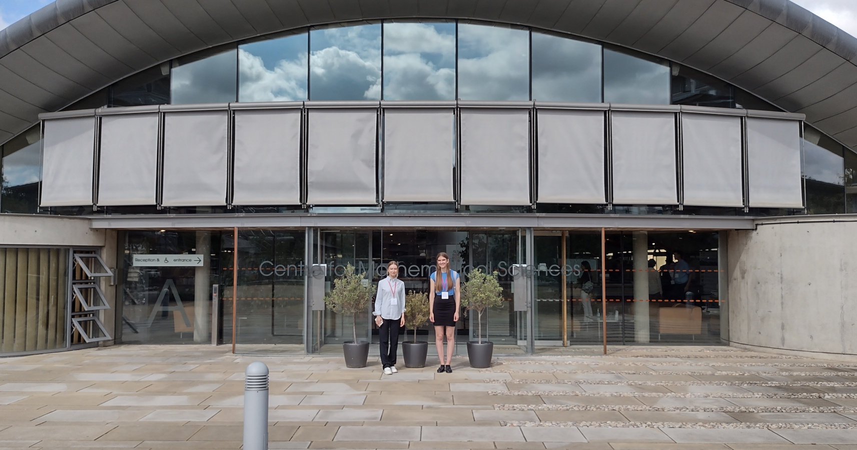 Ilona Basset and Emma Beniston standing in front of the Centre for Mathematical Sciences, Cambridge, UK