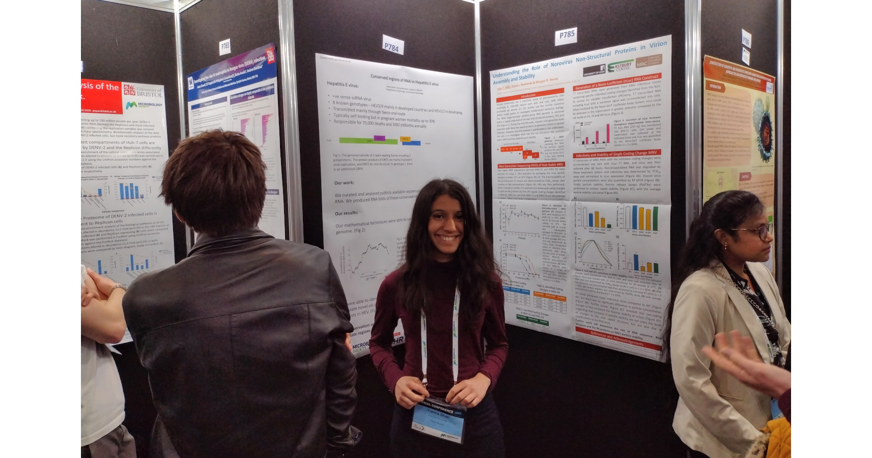 Vianca Shah standing in front of conference posters at the Microbiology Society conference 2023